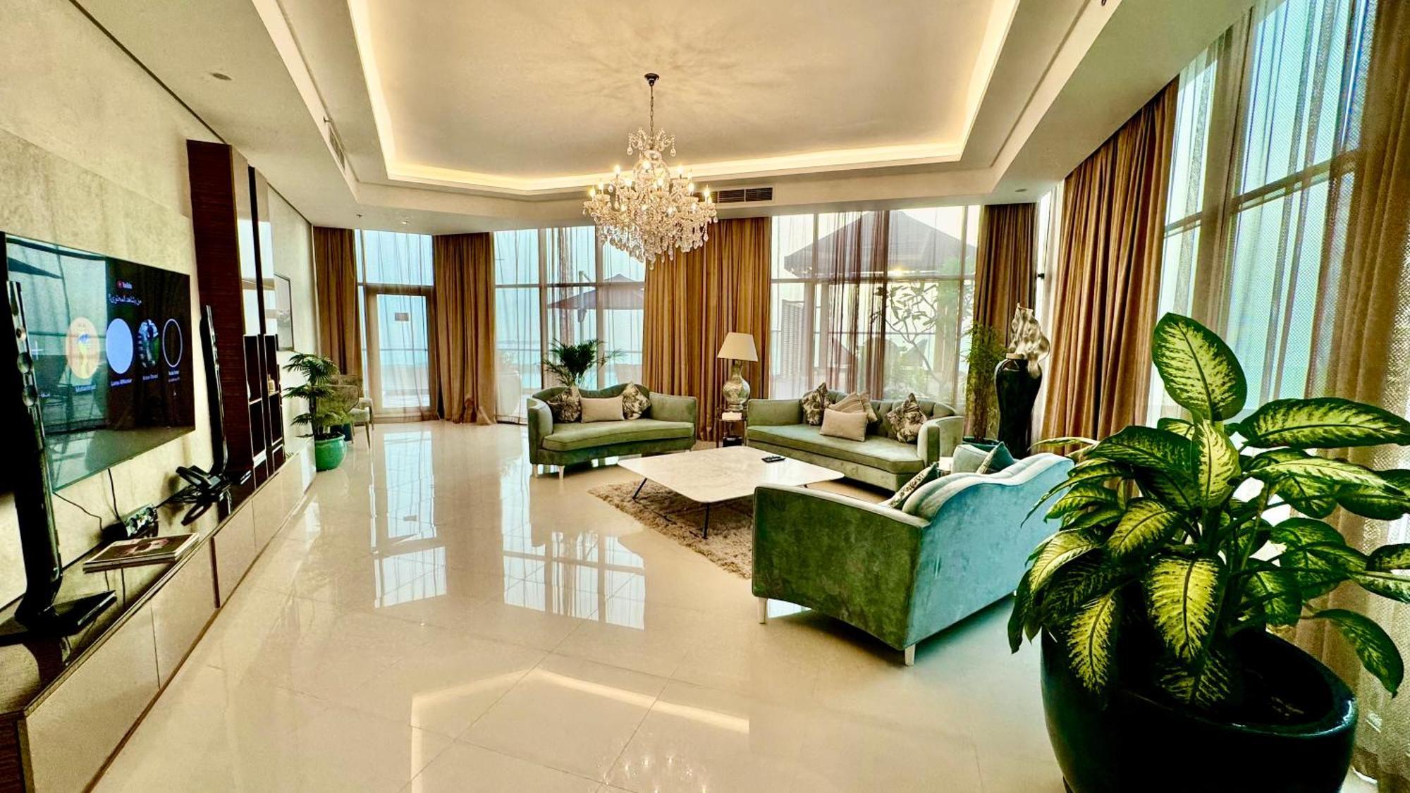 Lagoona Beach Luxury Resort And Spa Manama Dış mekan fotoğraf The photo depicts a spacious and elegantly designed living room. The room features large windows allowing natural light to flood in, accompanied by sumptuous curtains. The furniture includes a pair of soft green sofas and a centerpiece coffee table s