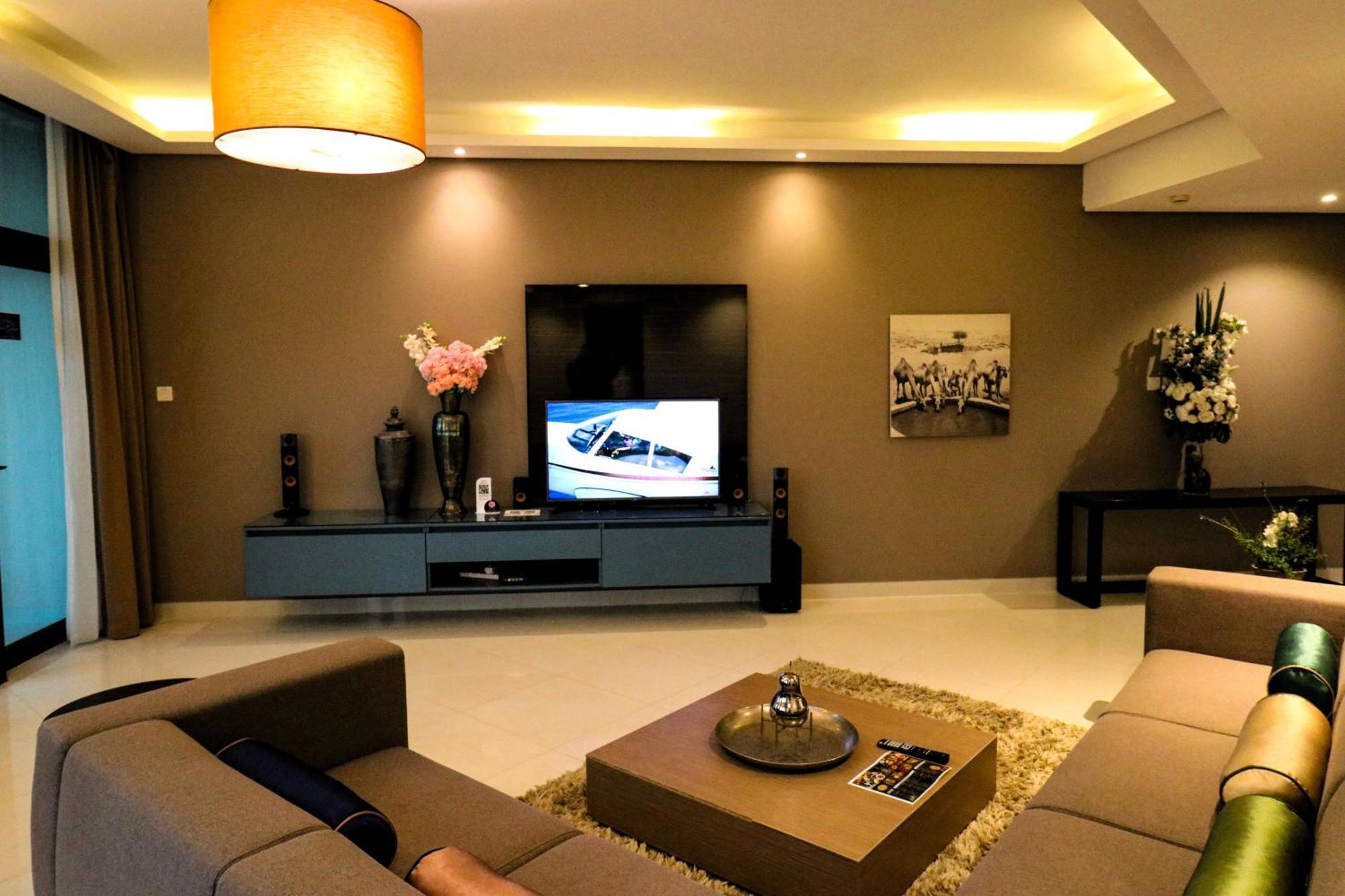 Lagoona Beach Luxury Resort And Spa Manama Dış mekan fotoğraf The photo shows a modern living room with a neutral color palette. Key features include:

- A comfortable seating area with a sofa arranged around a coffee table.
- A minimalist coffee table with a decorative item on top.
- A large flat-screen televi